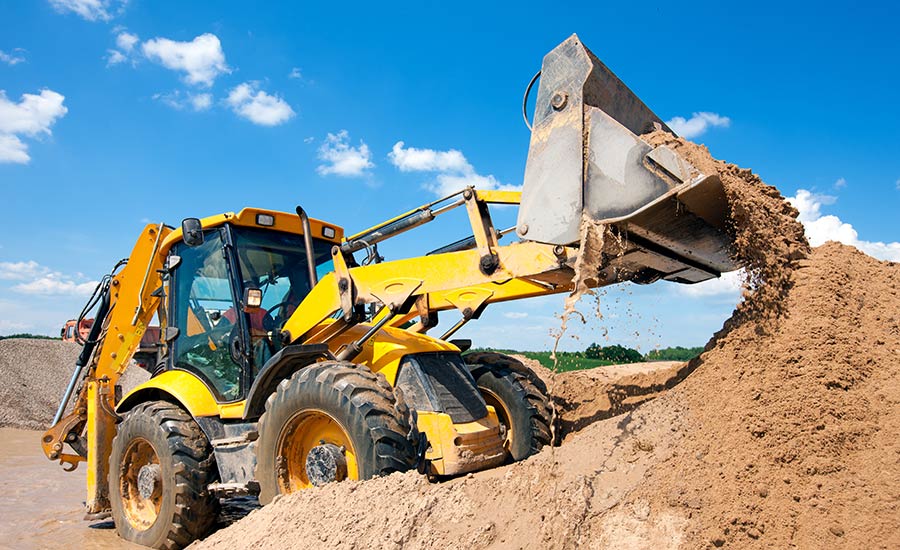 Baggermaschine entlädt Sand während der Erdarbeiten