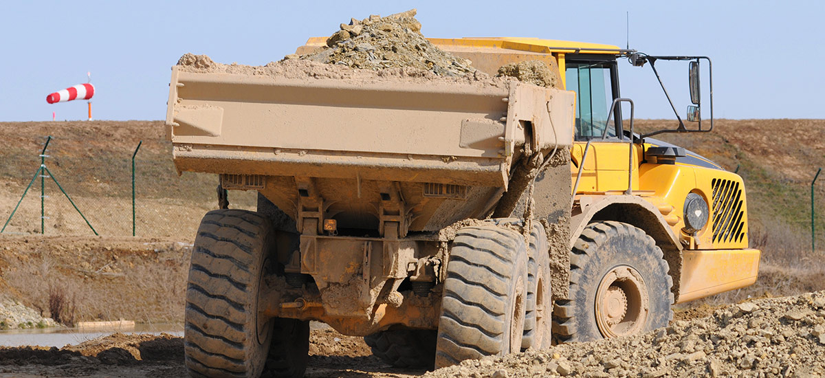 Baumaschine mit Erdaushub auf der Ladefläche