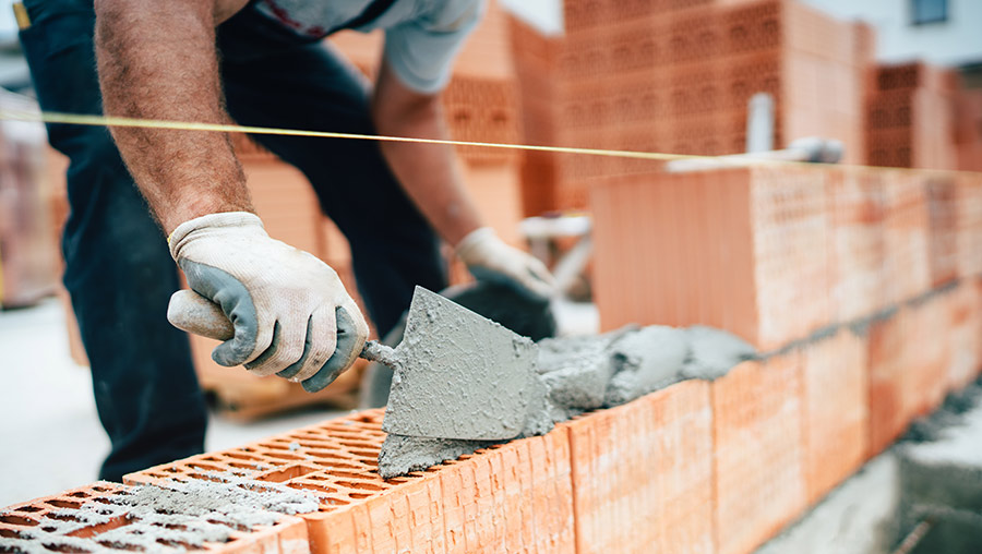 Arbeiter mit nachhaltigen Baustoffen beim Hausbau