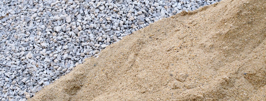 Zwei Haufen Kies und Sand die nebeneinander liegen.