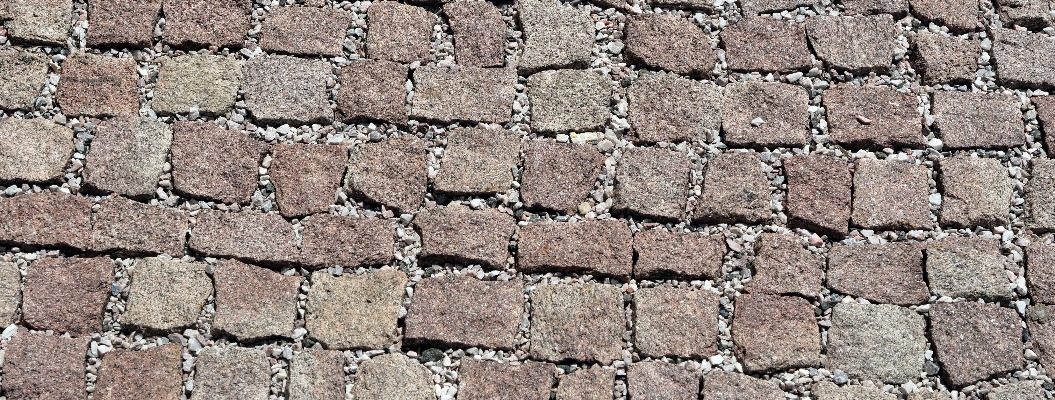 Verlegung von Kleinpflaster aus Naturstein mit Fugenmaterial.